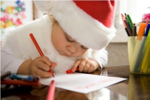 The small child writes the letter to Santa